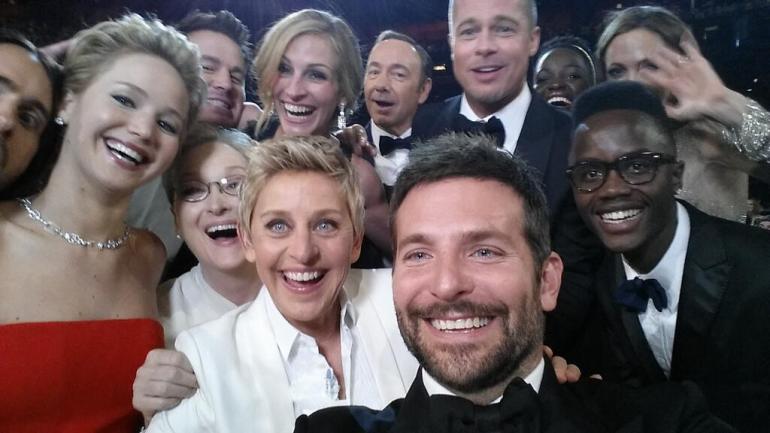 Ellen pulls celebrities from the crowd to take a selfie on twitter and breaks the record for most retweets.