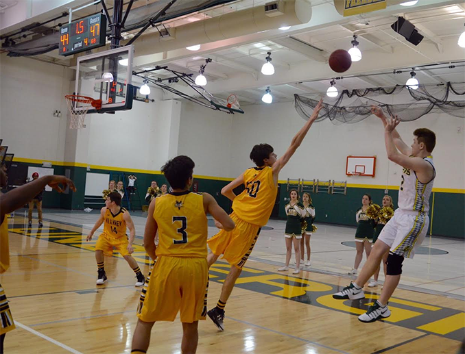 Ryan Lacefield (12) shoots the game tying three pointer at the end of the second half in the Vianney game. Later, in overtime, Lacefield made another last second shot to win the game.