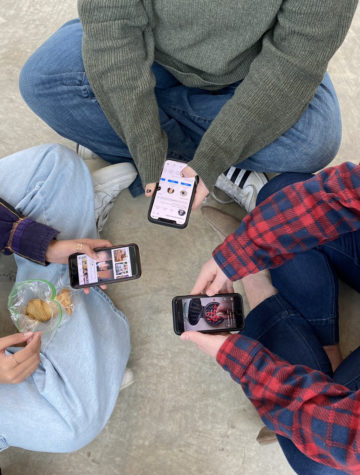 A group of students scroll on social media during lunch. Photo by Elizabeth Cleary.