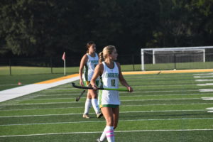Zoe Earley and Isabella Adams take the field at their varsity field hockey match.