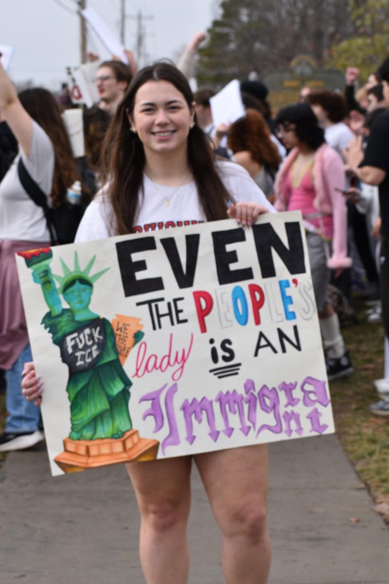 The walkout organizer, Lindbergh senior Kylie Stafford, holds up her protest sign. It says, "Even the people's lady is an immigrant."