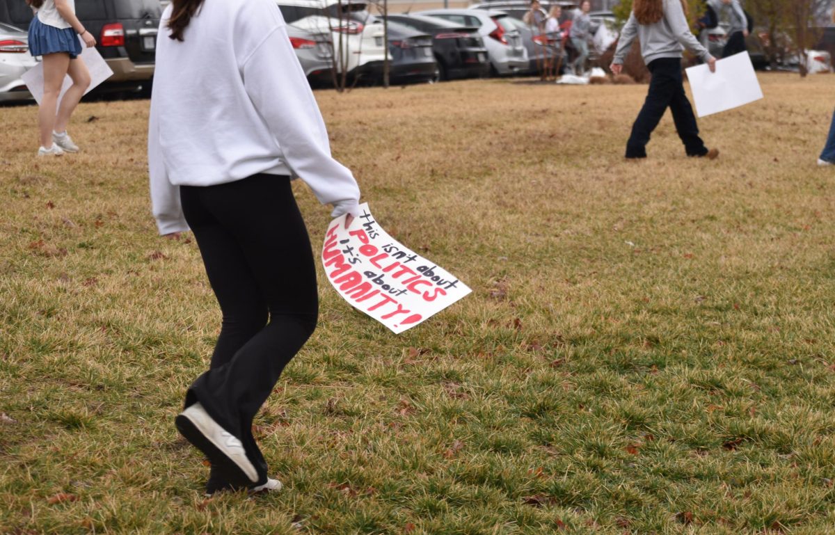 A protester is seen carrying a sign reading, "This isn't about politics, it's about humanity!"